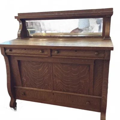Antique quarter-sawn oak sideboard featuring a mirrored back gallery shelf, upper drawers, and lower cabinet storage.