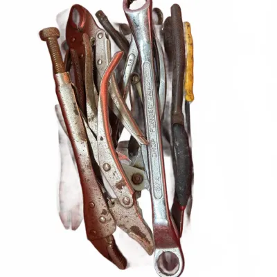 Assortment of vintage hand tools, including locking pliers and drop-forged box wrenches, showing heavy wear and patina.