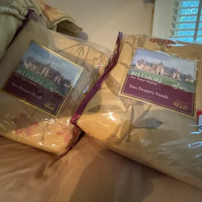 Two sets of unopened Biltmore For Your Home drapery panels featuring a floral pattern on gold fabric.