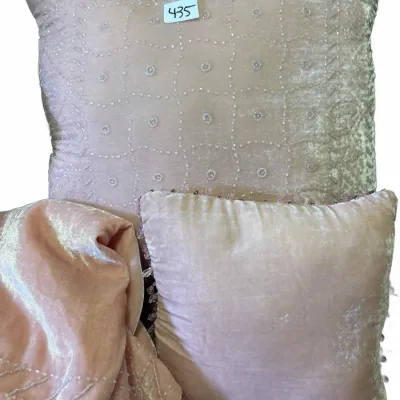 Blush pink crushed velvet throw pillows and matching fabric, featuring intricate hand-beaded lattice patterns and beaded trim.