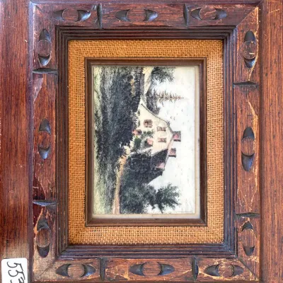 Framed miniature landscape drawing depicting a house among trees, housed in a carved wooden frame with a burlap liner.