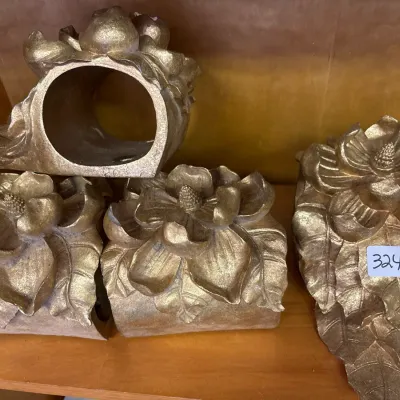 Set of four vintage metallic gold painted resin curtain tieback brackets featuring a detailed floral magnolia motif.