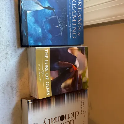 Stack of three hardcover and paperback books, including "Dreams & Dreaming," "The Lure of Gems" by Steve Bennett,...
