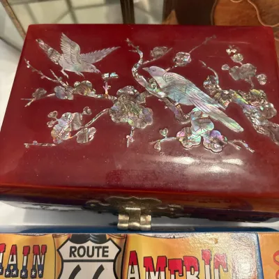 Vintage red lacquer jewelry box featuring mother-of-pearl inlay depicting birds perched on flowering cherry blossom branches.