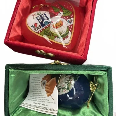 Two reverse hand-painted Li Bien glass Christmas ornaments in velvet padded display boxes.