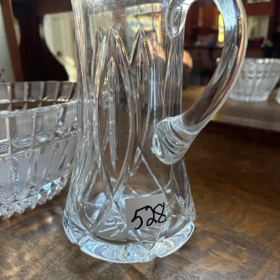 Tall vintage clear cut glass pitcher featuring elongated arch motifs and an applied loop handle.