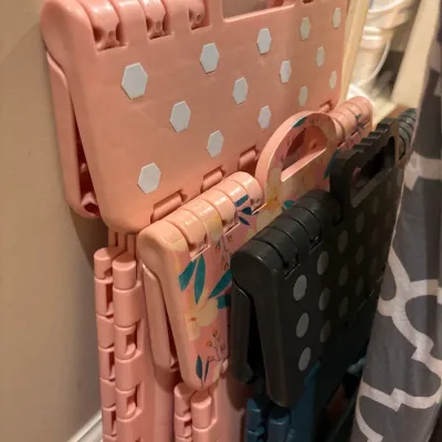 Set of three collapsible plastic step stools, including polka dot and floral designs.