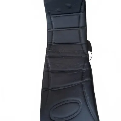Black padded massage seat pad featuring multiple ribbed sections and an oval lumbar support zone.