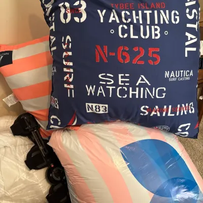 Nautica navy blue and red Tybee Island Yachting Club throw pillow along with additional striped pillows and household textiles.
