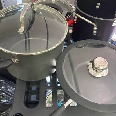 Assorted non-stick cookware set including stock pots and a skillet with glass lids.