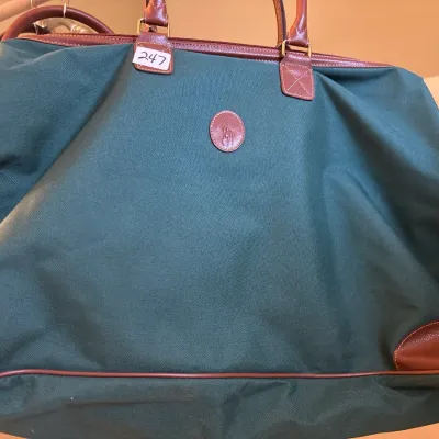 Vintage Polo Ralph Lauren dark green canvas duffle bag featuring brown leather trim and handles with an embossed leather logo patch.