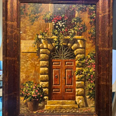 Framed vertical oil painting depicting a courtyard doorway in Piazza Navona, housed in a textured metallic-finish brown frame.
