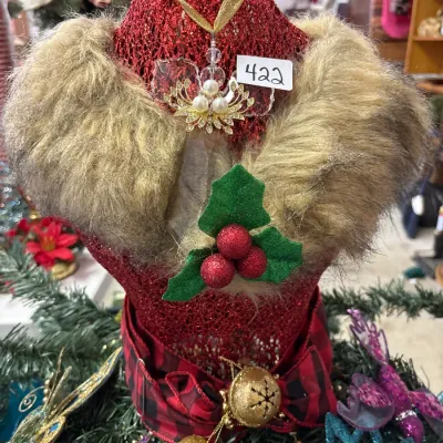 Festive red glitter mannequin dress form Christmas tree topper styled with faux fur collar, gold-tone faux pearl ornament, holly berries,...