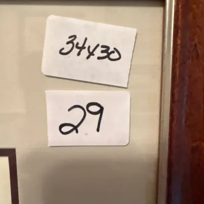 Framed picture with sticker labels indicating measurements of 34x30 and item number 29.