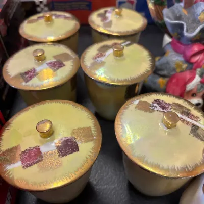 Set of six vintage lusterware lidded cups featuring a pale yellow finish with geometric gold and crimson accents.