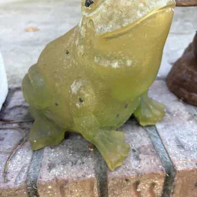 Vintage translucent yellow resin or plastic frog garden statue featuring textured skin details.