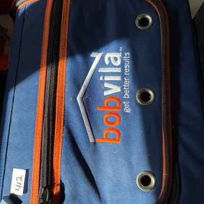 Bob Vila branded blue and orange canvas tool bag or binder organizer with zippered pockets and grommets.