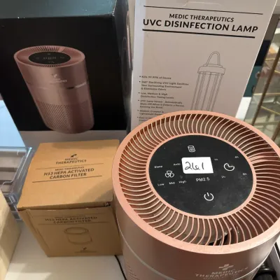 Medic Therapeutics rose gold air purifier unit with its original box, a replacement H13 HEPA activated carbon filter, and a boxed UVC...