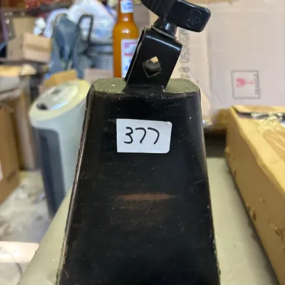 Black LP (Latin Percussion) metal cowbell with an attached mounting bracket, showing minor surface wear.