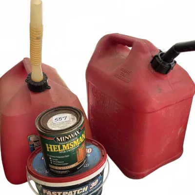 Assortment of garage items including two red plastic gas cans, a can of Minwax Helmsman spar urethane, and a small bucket of FastPatch 30...
