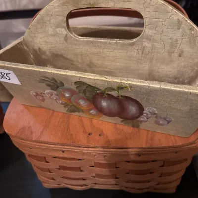 Hand-painted wooden tote with crackle glaze finish and fruit motif, resting atop a woven basket with a wooden lid.