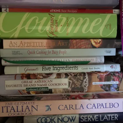 Stack of assorted hardcover and paperback cookbooks, including Gourmet Today, The Complete Cooking Light Cookbook, and The Ultimate...