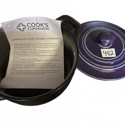Cook's Companion ceramic pot with a matching purple lid and original care instruction sheet.