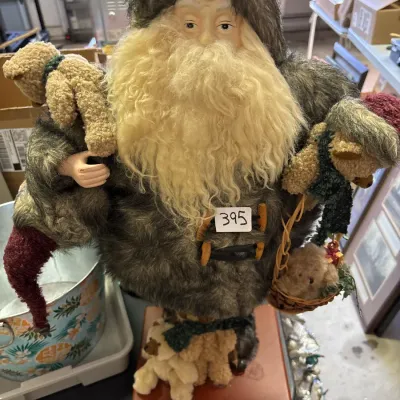 Vintage standing Santa Claus figure dressed in faux fur, featuring a long curly beard and carrying small teddy bears and a woven basket.