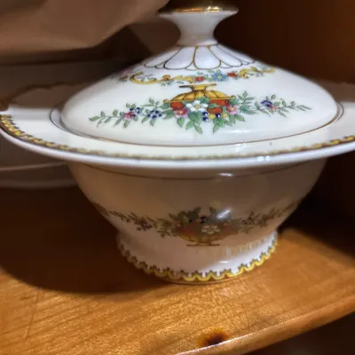 Vintage porcelain covered sugar bowl featuring a hand-painted floral motif with gold gilt accents.
