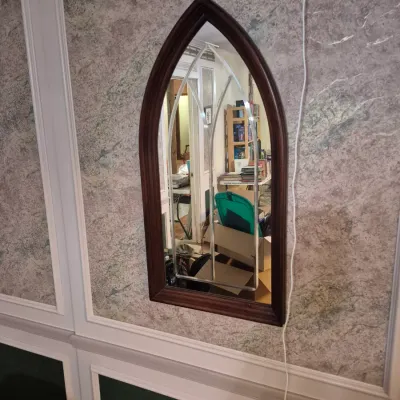 Sale Photo Thumbnail #74: Gothic arch wall mirror featuring a dark stained wood frame with silver faux tracery overlay.