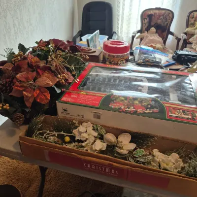 Sale Photo Thumbnail #25: Selection of holiday decor, featuring a boxed House of Lloyd Christmas garland, artificial poinsettia floral arrangement, and boxed train set.