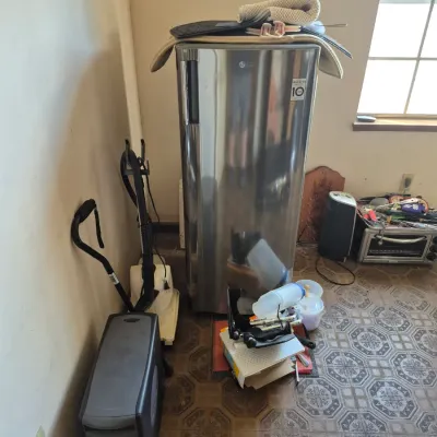 Sale Photo Thumbnail #82: Modern stainless steel LG single-door refrigerator shown alongside a computer tower, vacuum cleaner, small toaster oven, and miscellaneous household items.
