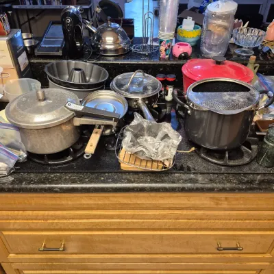 Sale Photo Thumbnail #54: Assorted vintage and modern kitchenware, including a Presto pressure cooker, bundt pans, stainless steel tea kettle, and various pots displayed on a kitchen island.