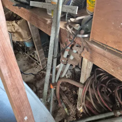 Sale Photo Thumbnail #94: Selection of vintage workshop tools and equipment, including pipe clamps, a metal T-square ruler, and coiled hoses.