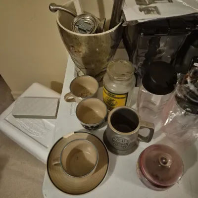 Sale Photo Thumbnail #65: Assorted vintage kitchenware and decor items including stoneware mugs, a Champion pewter tankard, a Ninja blender with manual, and a large ceramic vase.