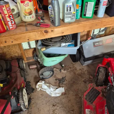 Sale Photo Thumbnail #110: Collection of garage and yard maintenance items including motor oils, lawn mowers, a fertilizer spreader, and various automotive fluids.