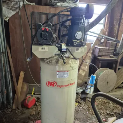 Sale Photo Thumbnail #92: Ingersoll Rand upright stationary air compressor mounted on a large vertical steel tank, showing surface dust from garage storage.