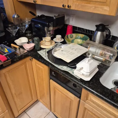 Sale Photo Thumbnail #56: Kitchen countertop with various housewares, including martini glasses, an espresso machine, serving bowls, and a white ceramic tureen.