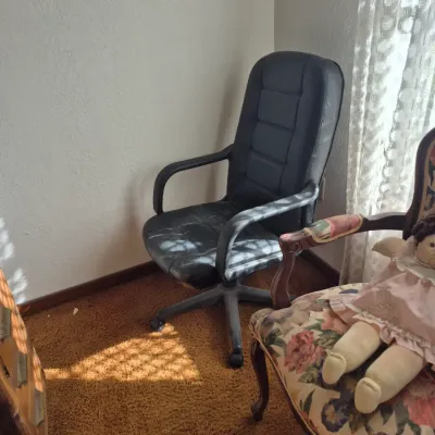 Sale Photo Thumbnail #19: Black faux leather high-back swivel office desk chair with fixed armrests and five-star wheeled base.