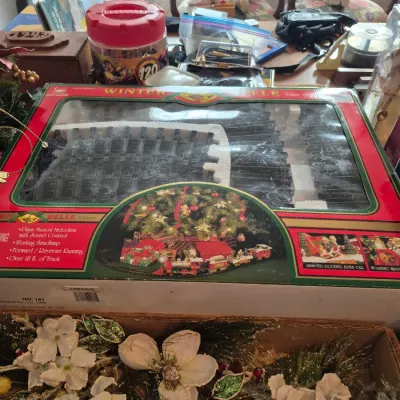 Sale Photo Thumbnail #27: Vintage Winter Belle musical train set in original packaging, accompanied by a box of festive faux floral arrangements.