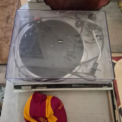 Sale Photo Thumbnail #41: Vintage Technics Quartz SL-Q2 direct-drive automatic turntable system with clear dust cover, accompanied by a yellow and maroon Makita hat.