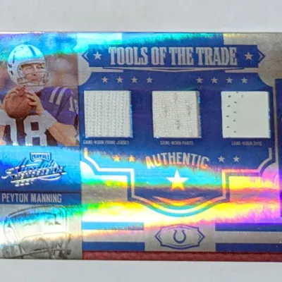 Peyton Manning Playoff Absolute Memorabilia Tools of the Trade holographic trading card featuring game-worn jersey, pants, and shoe relic...
