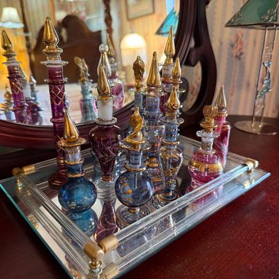 Collection of ornate vintage Egyptian-style blown glass perfume bottles with gold leaf details.