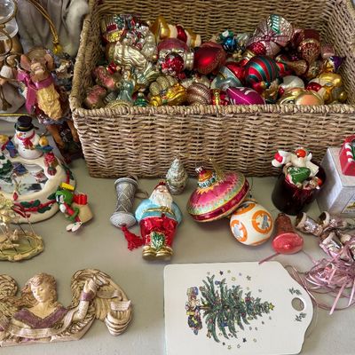 Collection of vintage glass and resin Christmas ornaments, including a wicker basket filled with colorful glass baubles, figurines, and...