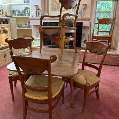French Country dining table set featuring carved wood frames with rush seats, including four side chairs and two armchairs.