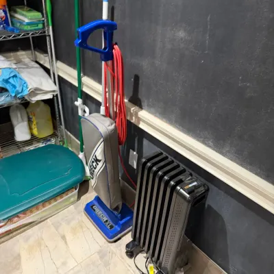 Sale Photo Thumbnail #264: Blue and grey Oreck XL upright vacuum cleaner standing next to a black portable oil-filled radiator heater.