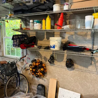 Sale Photo Thumbnail #232: Assorted garage items including wire shelving with paint cans, tools, storage tubs with seasonal decor, a metallic ornament wreath, and a cruiser bicycle.