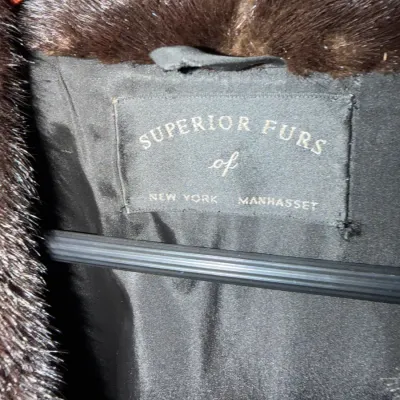 Interior lining label of a vintage dark brown fur coat, reading "Superior Furs of New York Manhasset".