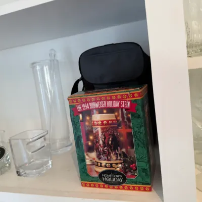 Sale Photo Thumbnail #163: Boxed 1994 Budweiser Holiday Stein "Hometown Holiday" alongside assorted glassware including a New York Jets rock glass and clear pitcher.