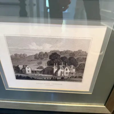 Framed black-and-white architectural engraving of Endsleigh Cottage, housed behind glass in a light wooden frame with double matting.